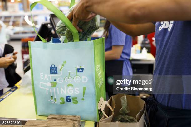 An employee bags groceries for a customer during the grand opening of a Whole Foods Market 365 location in Santa Monica, California, U.S., on...