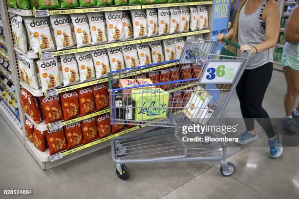 Customer pushes a cart with cases of LaCroix sparking water while shopping during the grand opening of a Whole Foods Market 365 location in Santa...