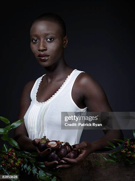 portrait of a black woman holding fruit - mother nature stock pictures, royalty-free photos & images