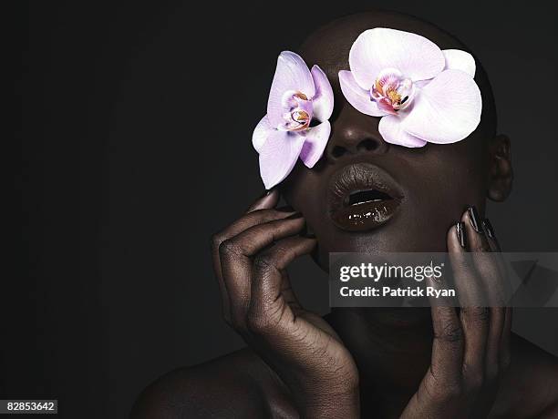 black woman with flowers covering her eyes - newcraft stock-fotos und bilder