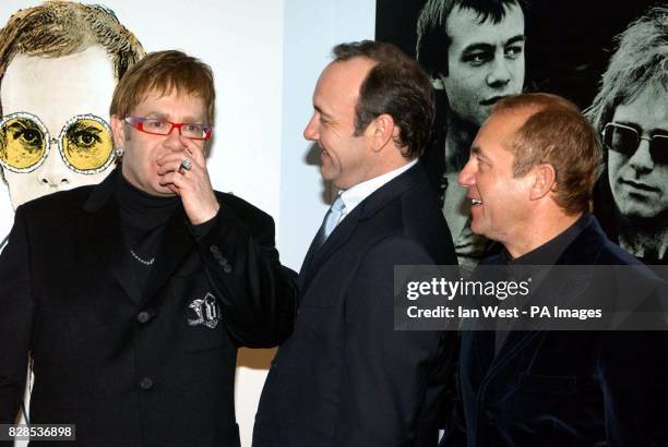 Sir Elton John , Kevin Spacey and Elton's songwriting partner Bernie Taupin pose for photographers as they arrive at the Music Industry Trust's...