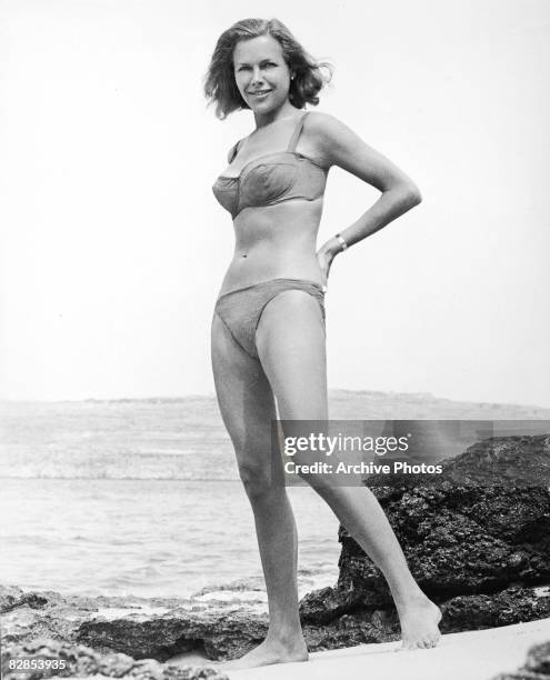 British actress Honor Blackman wearing a bikini on the set of the James Bond film, 'Goldfinger,' directed by Guy Hamilton, 1964.