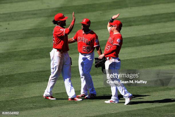 Ben Revere and Kole Calhoun congratulate Cesar Puello after defeating the Baltimore Orioles 5-1 in a game at Angel Stadium of Anaheim on August 9,...