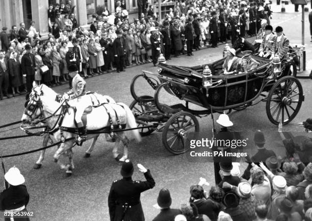 Royal Marines street-liner smartly presents arms as the Queen and King Baudouin of the Belgians drive out from Victoria Station, in an open coach at...
