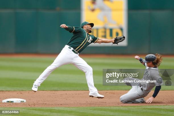 Ben Gamel of the Seattle Mariners steals second base as Marcus Semien of the Oakland Athletics fils to catch a ball thrown by catcher Bruce Maxwell...