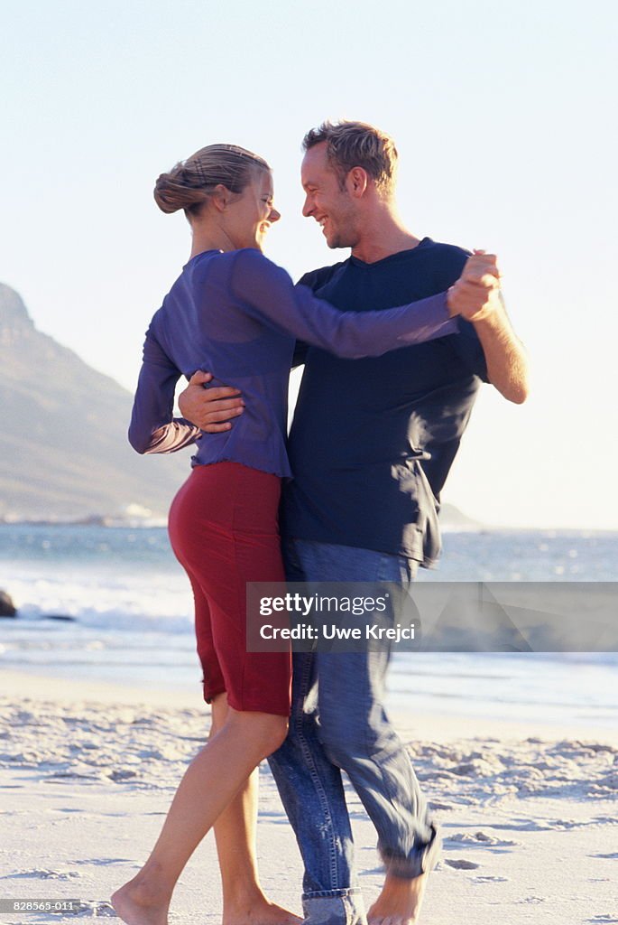 Young couple dancing on beach, close-up