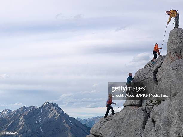 family of hikers on rock cliff, roped together - montanhismo imagens e fotografias de stock