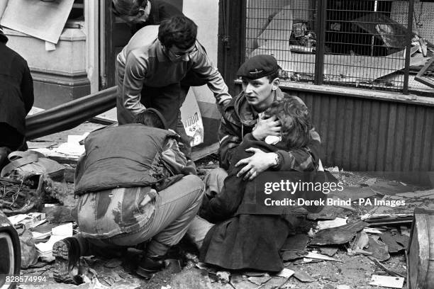 British paratrooper takes a young girl in his arms to comfort her after she had been hurt in the bomb blast in Donegal Street, Belfast.