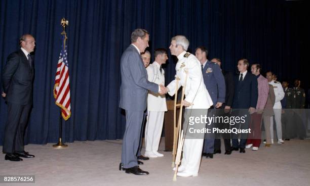 At a pre-dinner reception, US President Richard Nixon shakes hands greets former North Vietnamese prisoner of war Captain John McCain, Washington DC,...