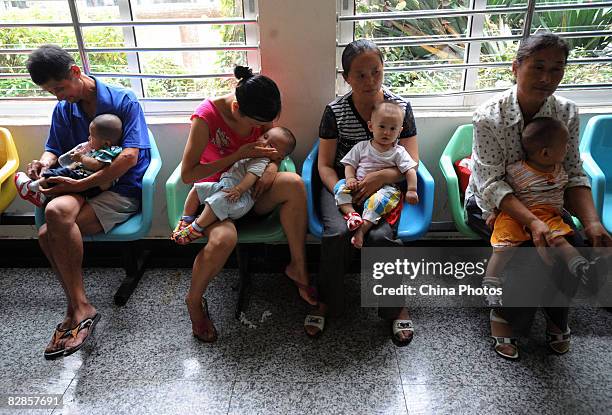 People holding babies who drank tainted milk powders, queue to receive type-B ultrasonic examination in a Hospital on September 17, 2008 in Wuhan of...