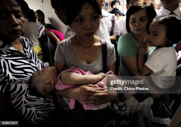 People holding babies who drank tainted milk powders, queue to receive type-B ultrasonic examination in a Hospital on September 17, 2008 in Wuhan of...