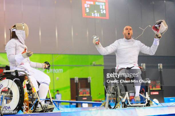Alberto Pellegrini of Italy takes off his mask as he wins the bronze medal after competing against Wing Kin Chan of Hong Kongin the Wheelchair...