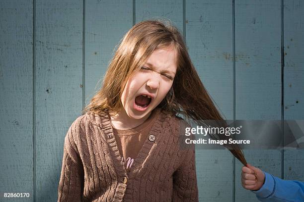 girl having hair pulled - hair pulling stock pictures, royalty-free photos & images