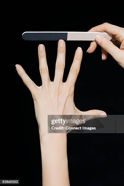 woman filing her nails - nagelfeile stock-fotos und bilder