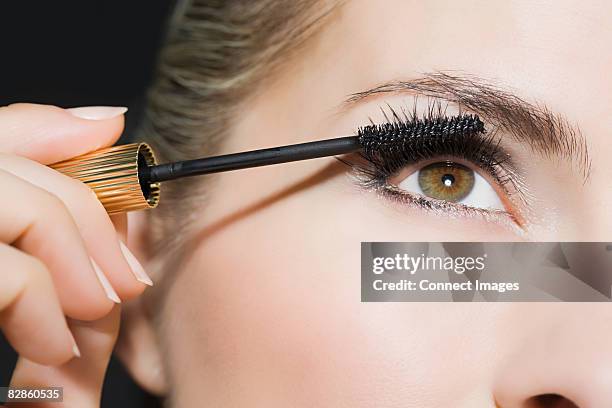 woman applying mascara - mascaras stock-fotos und bilder