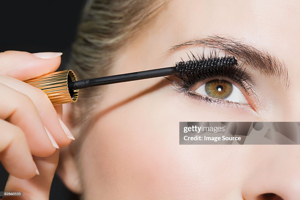 Woman applying mascara