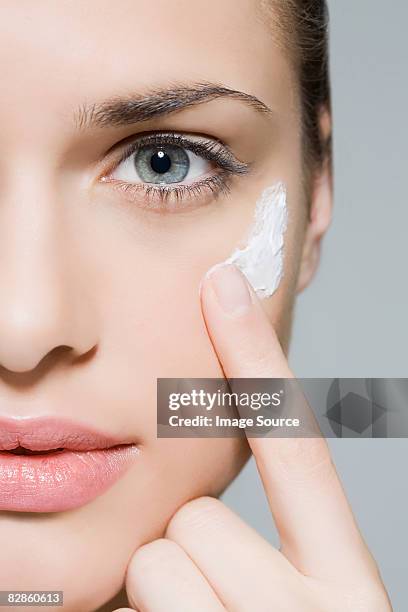 woman applying moisturiser - beauty studio moisturisers stock pictures, royalty-free photos & images