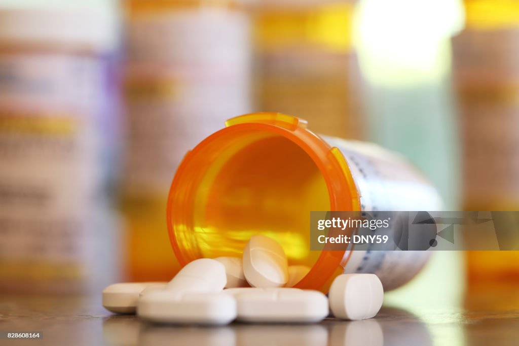 Pills Pour Out Of Prescription Medication Bottle Onto Kitchen Counter