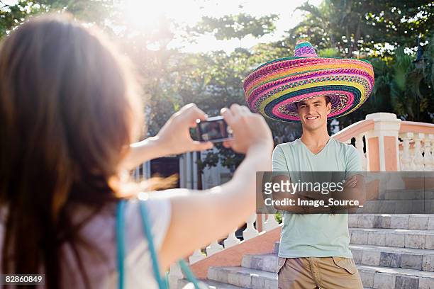 woman photographing man wearing sombreros - mexican hat stock pictures, royalty-free photos & images
