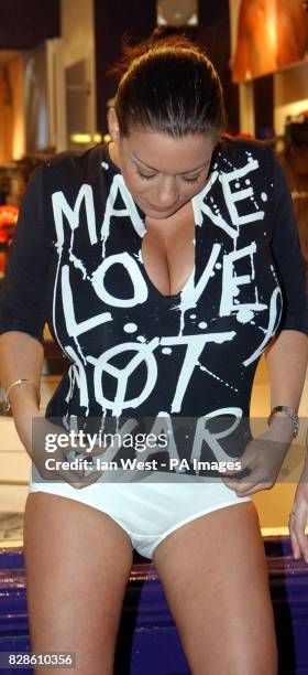 Model Linsey Dawn McKenzie wears a Make Love Not War t-shirt during a photocall at the Aware lingerie shop in London's Carnaby Street to protest...