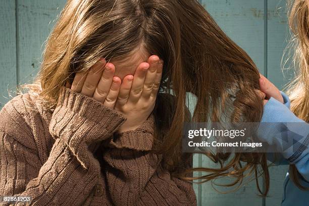 girl having hair pulled - pull a face foto e immagini stock