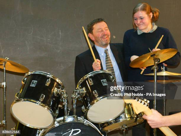 Home Secretary David Blunkett gets a drumming lesson from Terri Barley as he and Prime Minister Tony Blair jammed with a school band during a visit,...