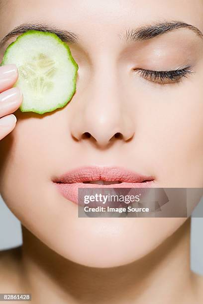 woman with cucumber over her eye - compassionate eye stock-fotos und bilder