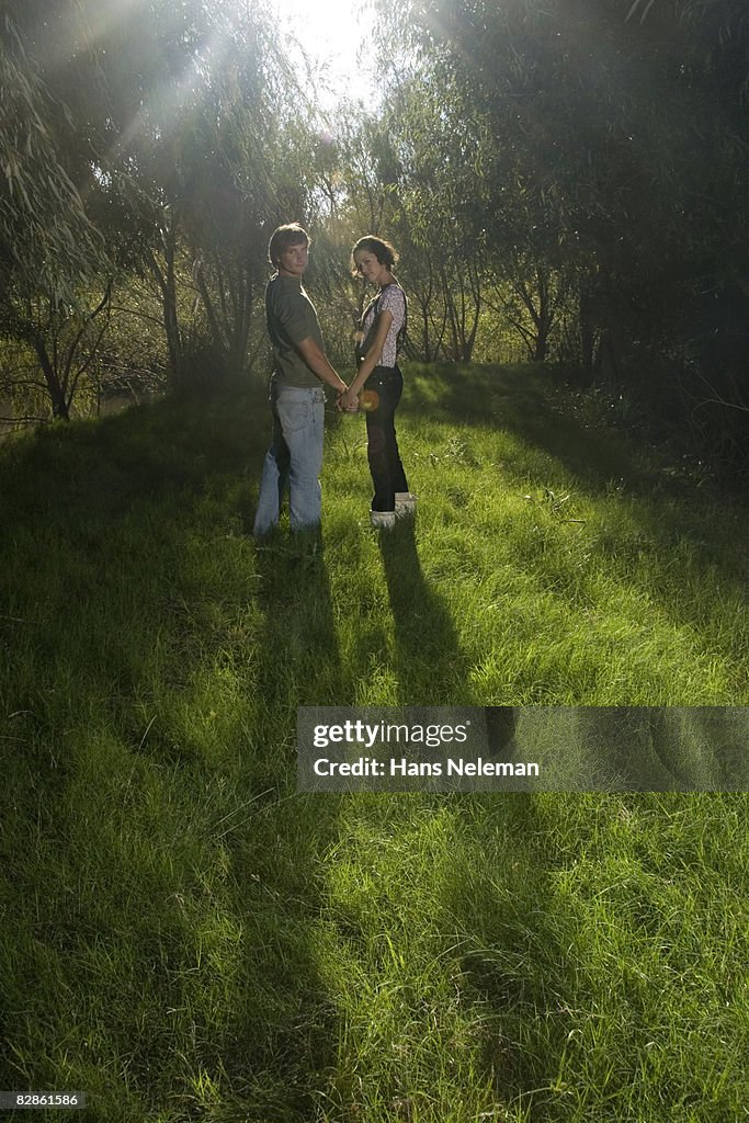 Young couple holding hands in the woods