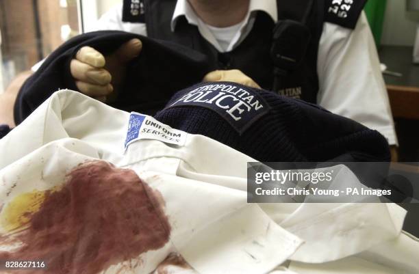 Police Officer displays the torn and bloody uniforms of colleagues who were attacked by a savage dog in Streatham, South London. Five Police Officers...