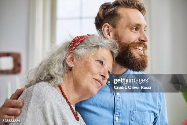 mother and smiling adult son - hijo adulto fotografías e imágenes de stock