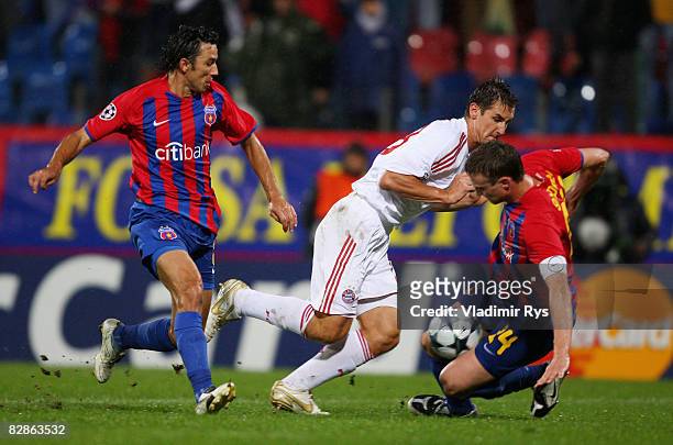 Miroslav Klose of Bayern attacks as George Ogararu and Sorin Ghionea of Bucharest defend during the UEFA Champions League Group F match between FC...