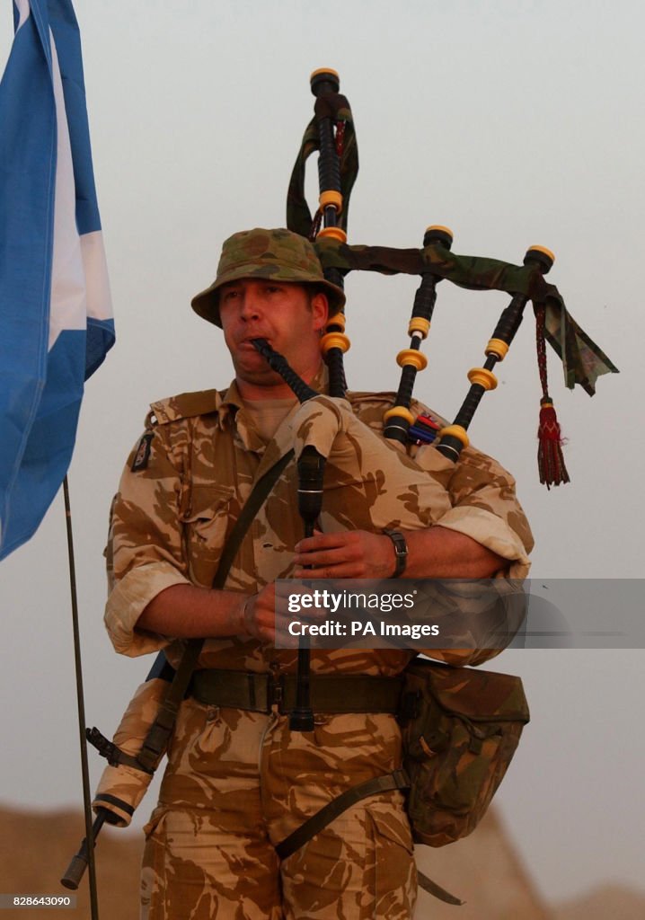 A Royal Scots Dragoon Guard plays his bagpipes in the Kuwait desert ...