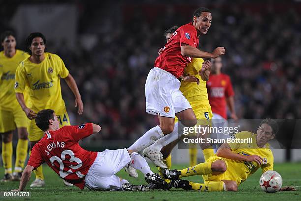 Rio Ferdinand and Jonny Evans of Manchester United challenge Guille Franco of Villareal for the ball during the UEFA Champions League Group E match...