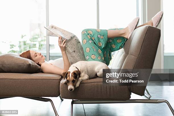 woman relaxing with dog - couch hund stock-fotos und bilder