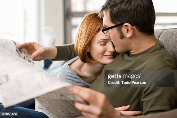 affectionate couple with newspaper - zeitung lesen zwei personen stock-fotos und bilder