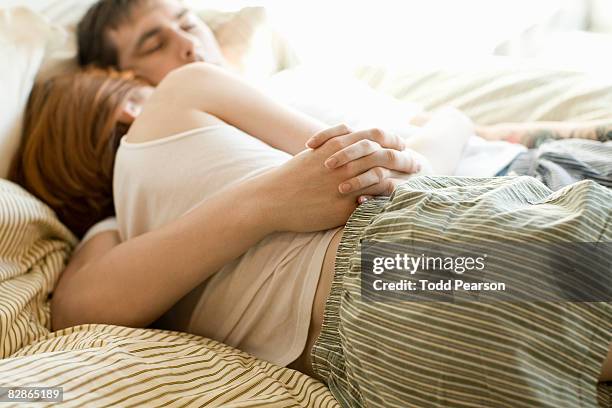 couple snuggling - pareja abrazados cama fotografías e imágenes de stock