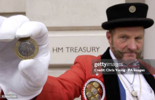 Ray Egan, dressed as John Bull, displays the Queens head on a two pound coin as he stages a Budget Day protest outside The Treasury in London. Mr...