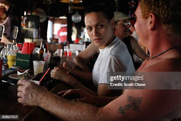 Destiny Lee and James McCormick have a drink at Robert's Lafitte bar following Hurricane Ike September 17, 2008 in Galveston, Texas. The bar has been...