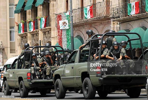 Soldiers ride on pickup trucks as they patrol the streets of Morelia on September 17, 2008 after deadly attacks. Mexico on September 17 focused on...
