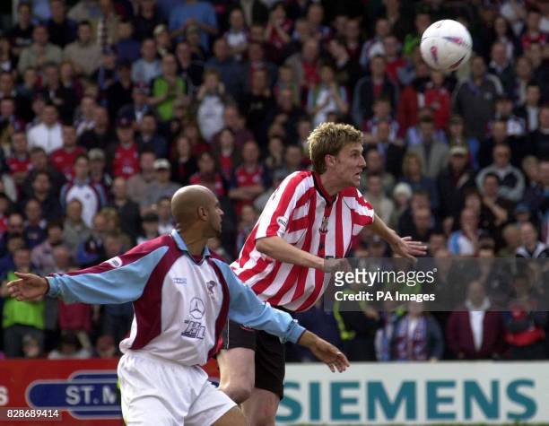 Lincoln's Ben Futcher heads clear, watched by Scunthorpe's Martin Carruthers during their Nationwide Division Three league semi-final 1st leg match...