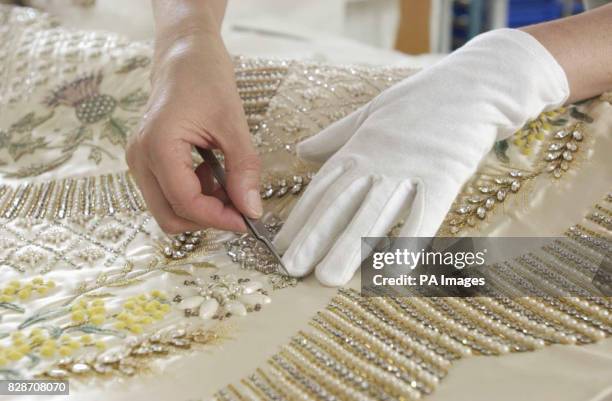 The Queen's Coronation dress of white satin is prepared, for the Summer Opening of Buckingham Palace's State Rooms by senior textile conservator...