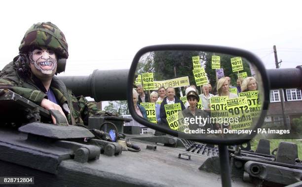 Protester Ed Jones, wearing a Tony Blair mask, sits on a tank outside the medieval Three Horseshoes pub at Mole Hill Green, Essex, near Stansted...