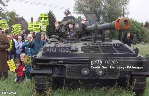 Protester Ed Jones, wearing a Tony Blair mask, sits on a tank outside the medieval Three Horseshoes pub at Mole Hill Green, Essex, near Stansted...