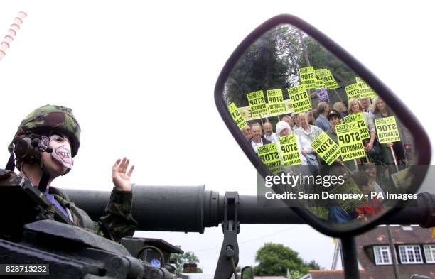 Protester Ed Jones, wearing a Tony Blair mask, sits on a tank outside the medieval Three Horseshoes pub at Mole Hill Green, Essex, near Stansted...