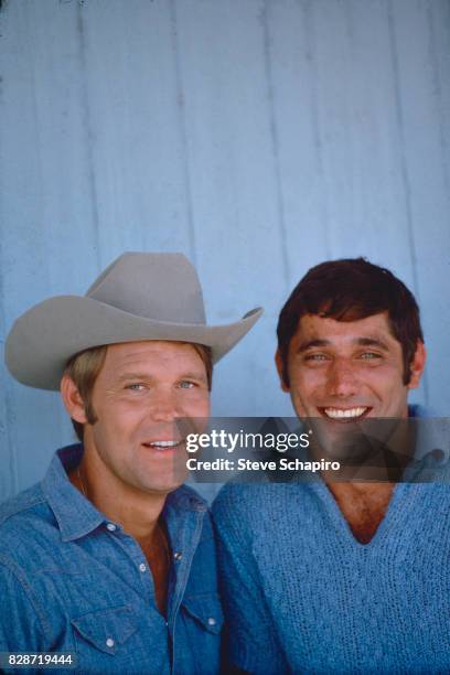 Portrait of American musician Glen Campbell and football player Joe Namath as they pose together at Campbell's home, Los Angeles, California, 1978.