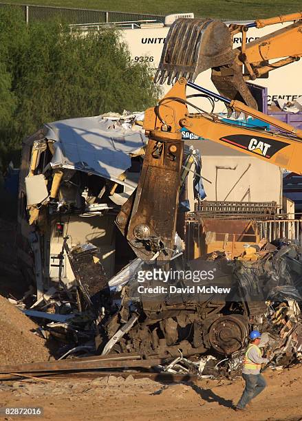 Workers remove the remains of a Metrolink commuter train on September 14, 2008 in Chatsworth, California. The Metrolink commuter train was involved...