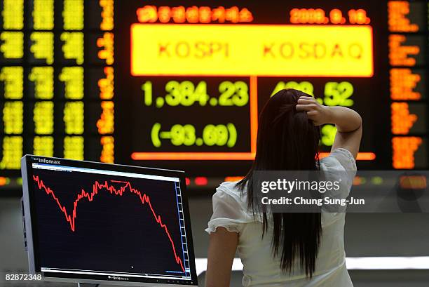 Woman looks at a board showing stock price index at a stock brokerage firm on September 16, 2008 in Seoul, South Korea. The Korean stock markets has...