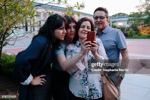 smiling family looking at smartphone in outdoor setting - toledo ohio fotografías e imágenes de stock