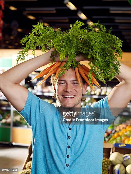 young man wearing carrots on head - lustig bunt bildbanksfoton och bilder
