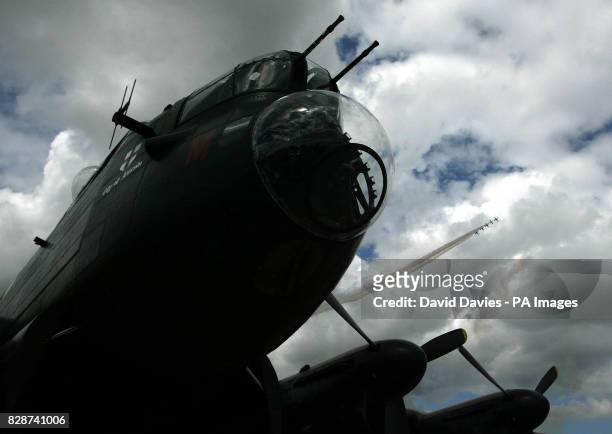 The distinctive nose of the Lancaster B1 Bomber stands in the 100 Years of Flight Exhibition as its more modern counterparts display over head at the...